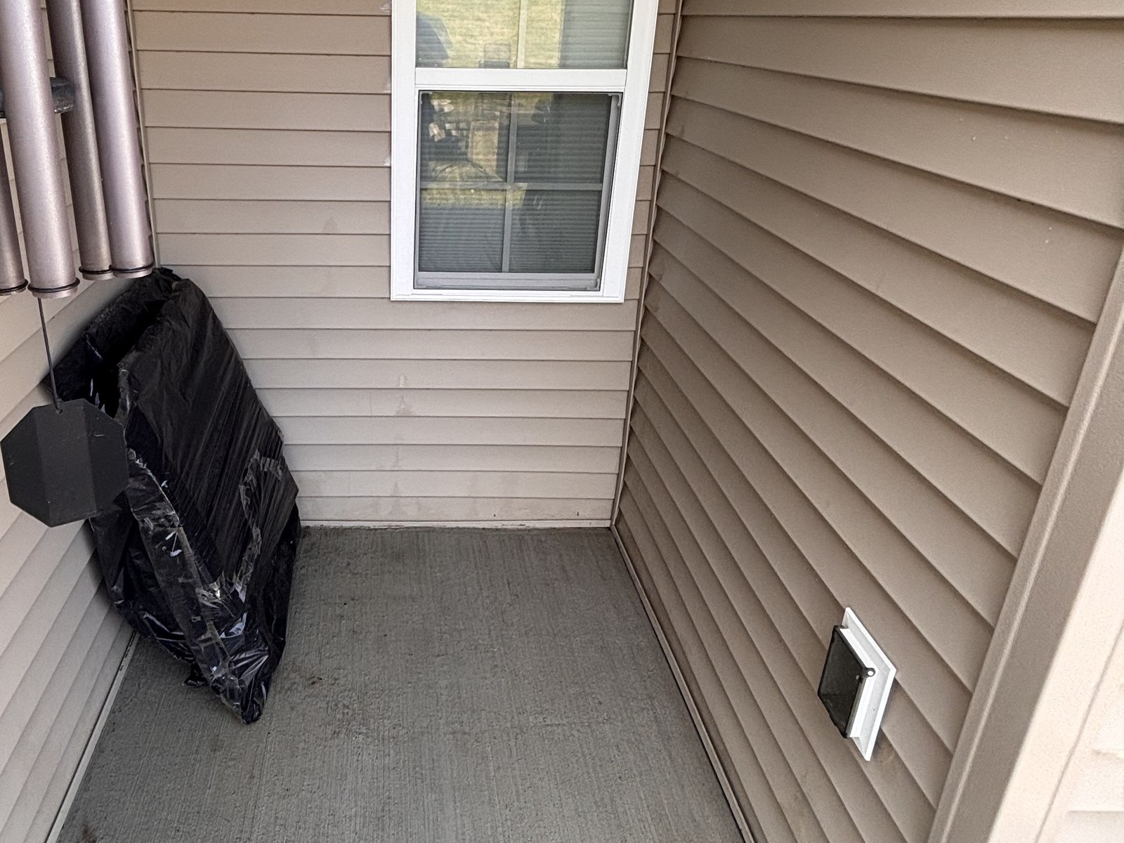 The same porch after cleaning, with clear concrete and freshly washed vinyl siding